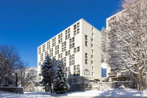 a large white building with snow on the ground at RockyPop Flaine Hotel & Spa in Flaine