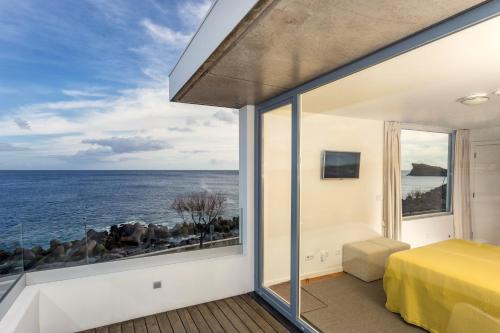 a bedroom with a view of the ocean at Ocean View by Azores Villas in Ponta Delgada