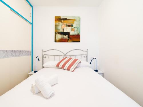 a white bedroom with a white bed with two pillows at Amarre Port in Puerto de Mogán