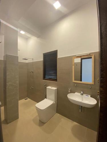 a bathroom with a toilet and a sink at Dimuthu Home in Ambalangoda