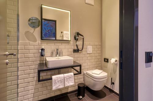 a bathroom with a sink and a toilet at Vienna House Easy by Wyndham Bonn City in Bonn