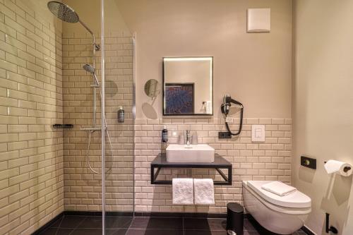 a bathroom with a shower and a sink and a toilet at Vienna House Easy by Wyndham Bonn City in Bonn