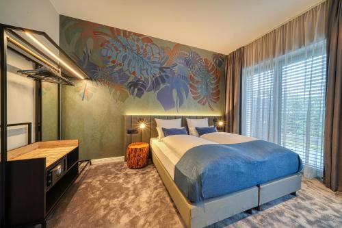 a bedroom with a large bed and a television at Vienna House Easy by Wyndham Bonn City in Bonn