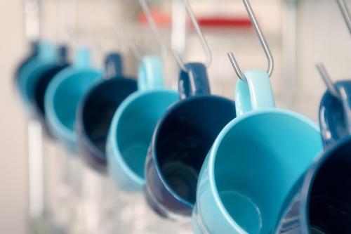 a row of blue cups hanging on a wall at Princes Street Hostel in Edinburgh