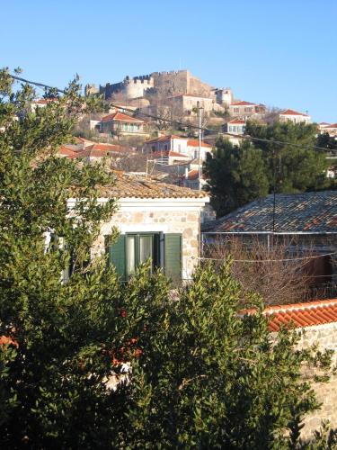 a building on a hill with trees in the foreground at Eleana Residence in Mithymna