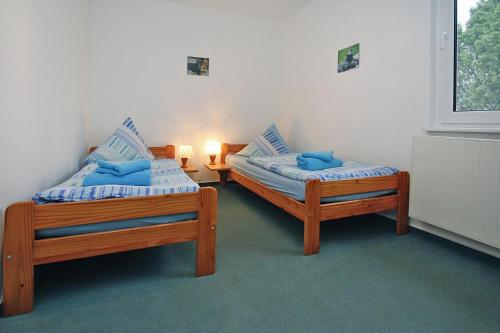 2 aparte bedden in een kamer met een raam bij Holiday homes Inselblick, Lohmen in Lohmen