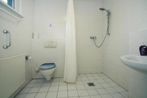 Baño blanco con aseo y lavamanos en Holiday homes Inselblick, Lohmen en Lohmen