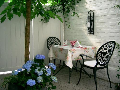 Hotel Kurpfalzstuben في مانهايم: طاولة وكراسي على فناء به زهور