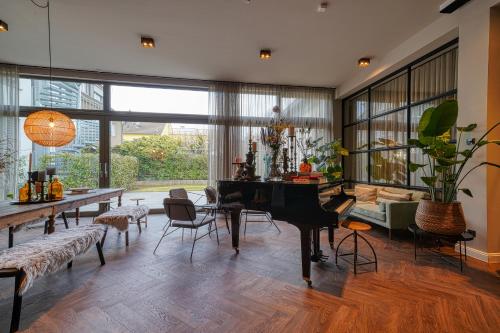 a living room with a table and a grand piano at Vienna House Easy by Wyndham Bonn City in Bonn