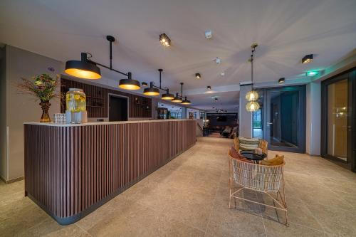 a lobby with a bar and chairs in a building at Vienna House Easy by Wyndham Bonn City in Bonn