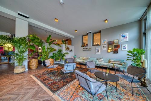 a lobby with tables and chairs and plants at Vienna House Easy by Wyndham Bonn City in Bonn