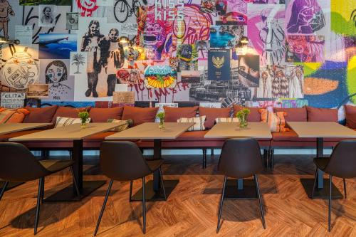 a room with tables and a wall with graffiti at Vienna House Easy by Wyndham Bonn City in Bonn