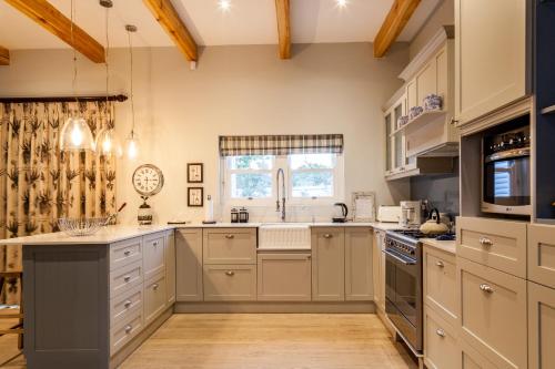 a kitchen with white cabinets and a window at Karoo Masterclass House and Karoo Masterclass Cottage - Accommodation Prince Albert in Prince Albert