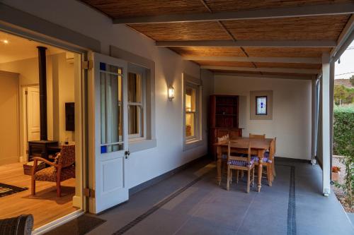 a porch with a table and chairs and a door at Karoo Masterclass House and Karoo Masterclass Cottage - Accommodation Prince Albert in Prince Albert