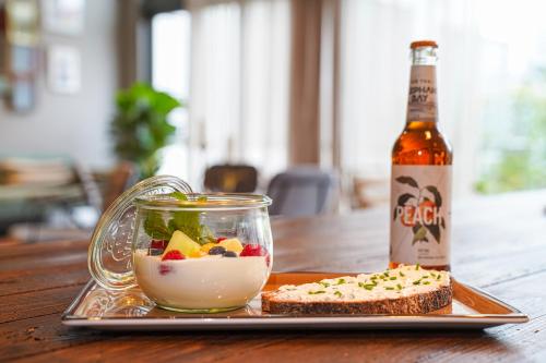 a bottle of beer and a plate of food and a sandwich at Vienna House Easy by Wyndham Bonn City in Bonn