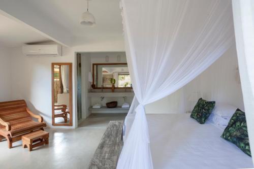 a white room with a bed and a chair at DA GRAÇA HOTEL in Trancoso