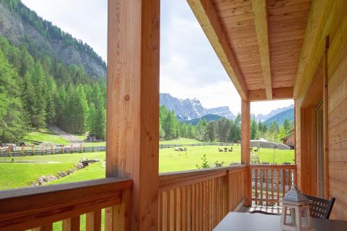 a porch with a view of a field and mountains at Chalet Mornà in San Martino in Badia