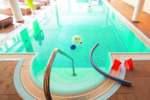 a swimming pool with a ball in the middle of it at Naturresort & Spa Schindelbruch in Stolberg i. Harz
