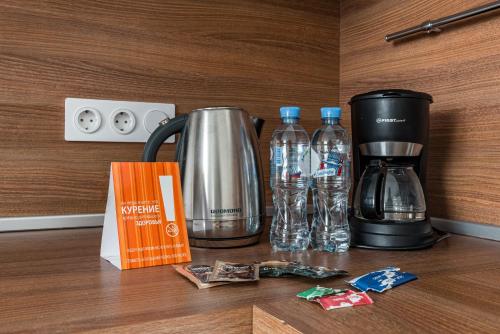 a coffee maker and water bottles on a counter at Апарт-отель YE'S Mitino in Moscow