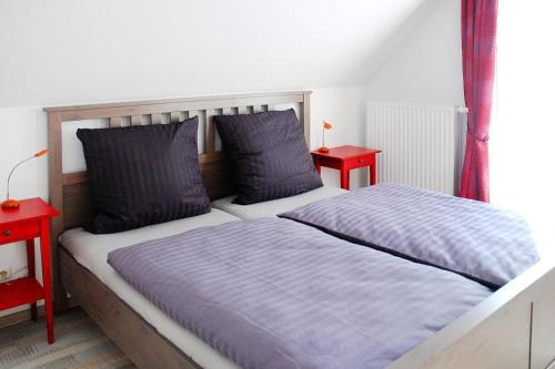 a bedroom with two beds and two red tables at Semi-detached house Rügentraum, Glowe in Glowe