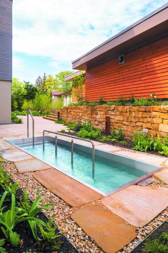 a swimming pool in front of a house at Naturresort & Spa Schindelbruch in Stolberg i. Harz