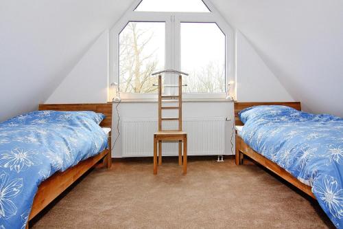 a bedroom with two beds and a ladder next to a window at Doppelhaushälfte Sprotte am Breetzer Bodden in Vieregge in Vieregge