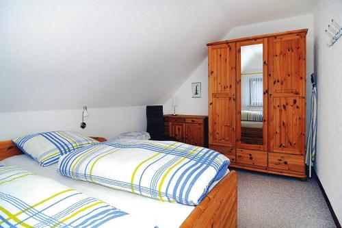 - une chambre avec 2 lits et une armoire en bois dans l'établissement Semi-detached house, Friedrichskoog-Spitze, à Friedrichskoog-Spitz