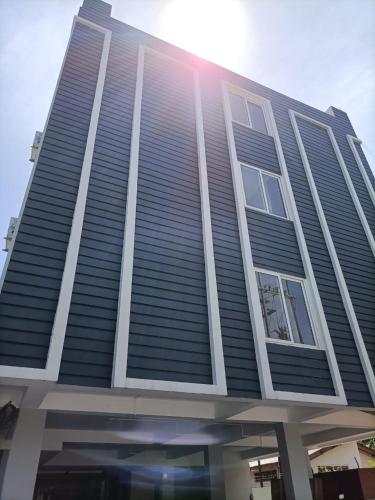 a tall building with the sun in the background at Grey House Inn in Guwahati