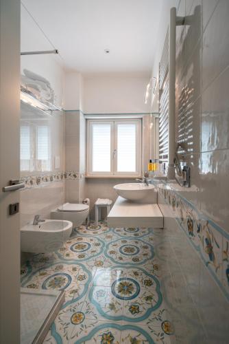 a bathroom with two sinks and two toilets at Park Hotel Villa Maria in San Menaio
