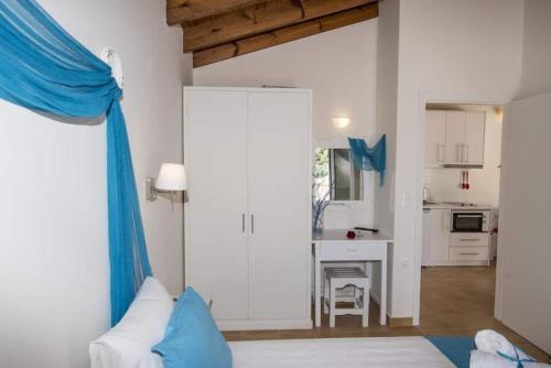 een woonkamer met een blauw gordijn en een keuken bij Filoxenia Kirki Apartments by CorfuEscapes in Benitses