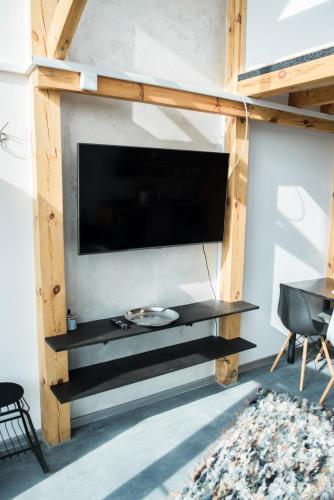 a living room with a large tv on a wall at Nowe domy na Mazurach- Totutaj Wejsuny in Pisz