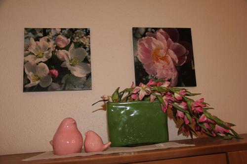a green vase sitting on a shelf with flowers at Hotel Kurpfalzstuben in Mannheim