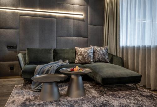 a living room with a couch and a table at Wellness- & Sporthotel Jagdhof in Röhrnbach