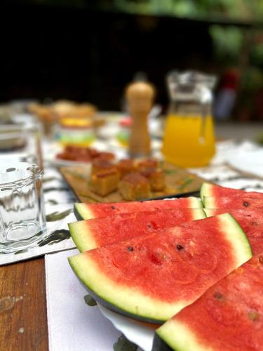 a table topped with slices of watermelon and orange juice at Vanilla County in Vagamon