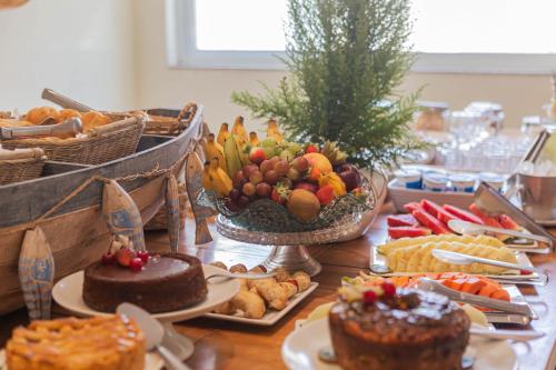 a table topped with different types of desserts and cakes at Hotel VillaReal Charme in Guaratuba