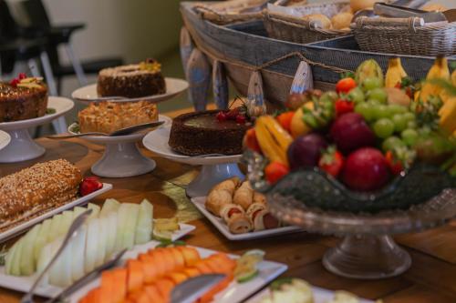a table topped with lots of different types of food at Hotel VillaReal Charme in Guaratuba