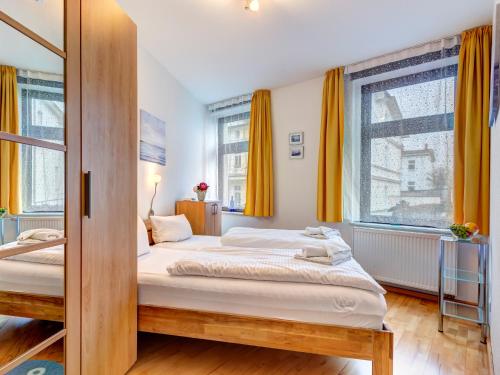 a bedroom with two beds and two windows at Haus Meerblick - 04 in Ahlbeck