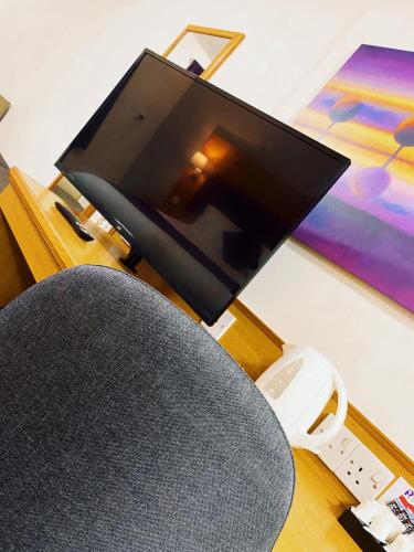 a living room with a tv and a chair with a wii controller at Purple Roomz Preston South in Preston