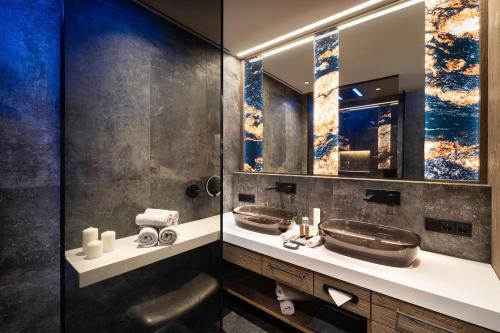 a bathroom with two sinks and a mirror at Wellness- & Sporthotel Jagdhof in Röhrnbach