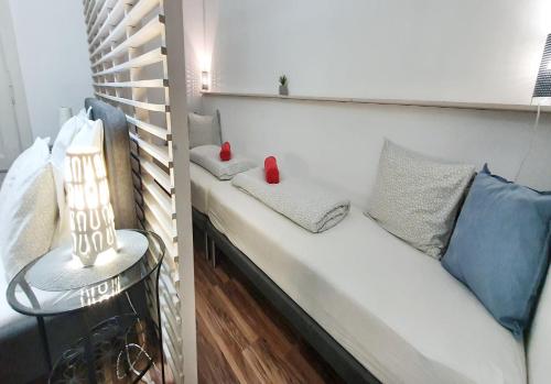 a room with a white bench with a blue couch at Dora Holiday House & Apartments in Keszthely
