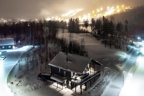 a house in the snow at night with lights at Luksushuvila Villa Marvik in Himos