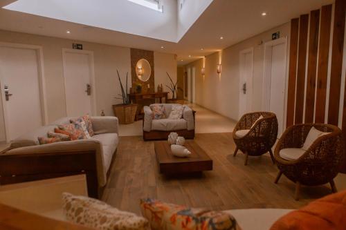 a living room with a couch and chairs and a table at Hotel VillaReal Charme in Guaratuba