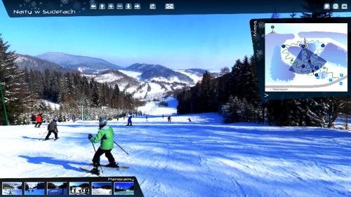 a group of people skiing down a snow covered slope at Dwa Dęby in Lubawka