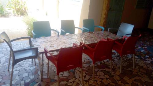 a dining room table with red chairs and a table and chairsktop at ESPACE COLIBRI in Palmarin