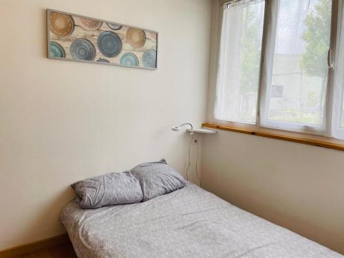une petite chambre avec un lit et une fenêtre dans l'établissement Studio avec la fibre et jardin, au coeur de Lorient, à Lorient