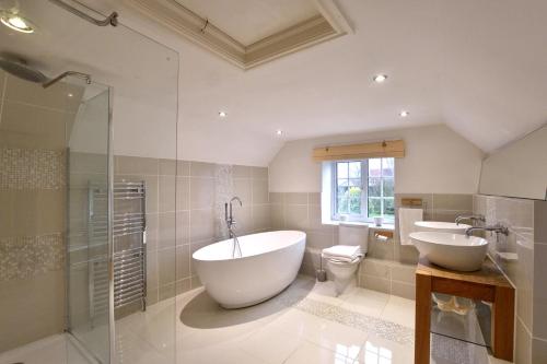 a bathroom with a tub and a sink and a toilet at Pass the Keys Scampton Cottage in Lincoln