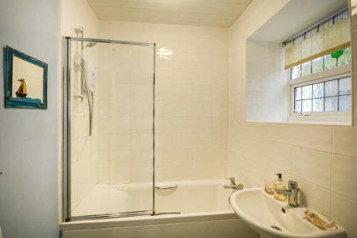 a bathroom with a shower and a sink at Rose Cottage - Kingsand in Kingsand