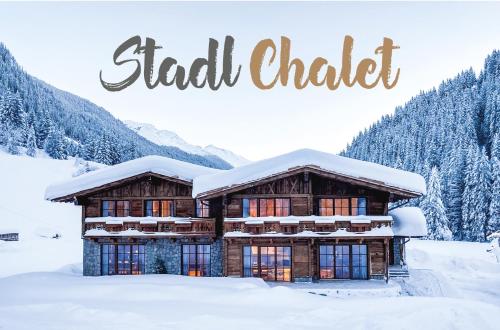 eine Blockhütte im Schnee mit den Worten Ski Chalet in der Unterkunft Stadl Chalet Ischgl in Ischgl