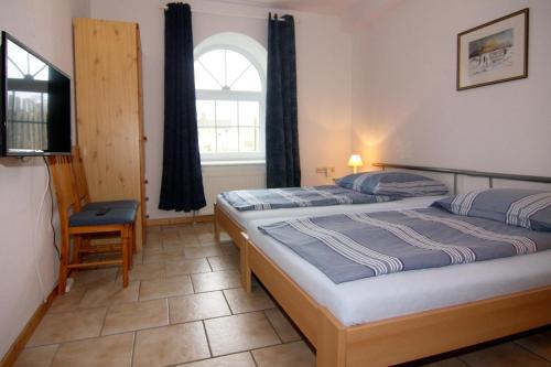 a bedroom with two twin beds and a window at Ferienwohnanlage Gut Bundhorst, Stolpe in Stolpe