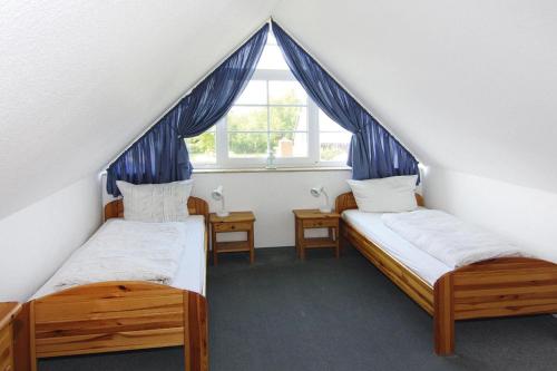 zwei Einzelbetten in einem Zimmer mit Fenster in der Unterkunft Ferienanlage Schuldt, Behrensdorf in Behrensdorf